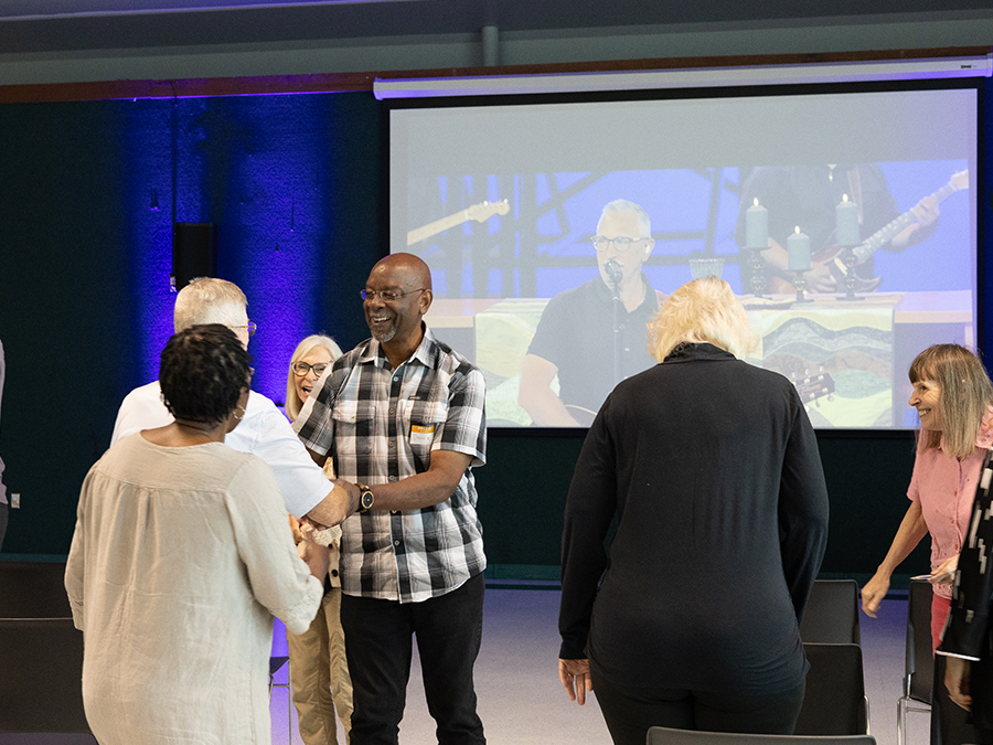 Congregation members greeting each other at weekend worship