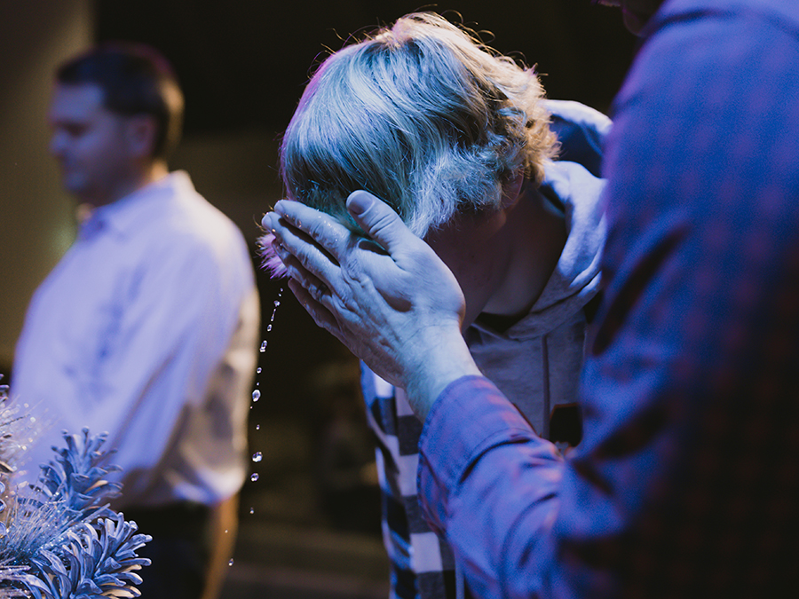 boy getting baptized with water