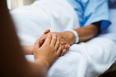 praying with patient in hospital bed