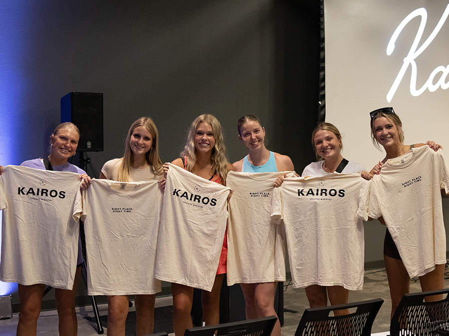 Group of girls holding Kairos t-shirts